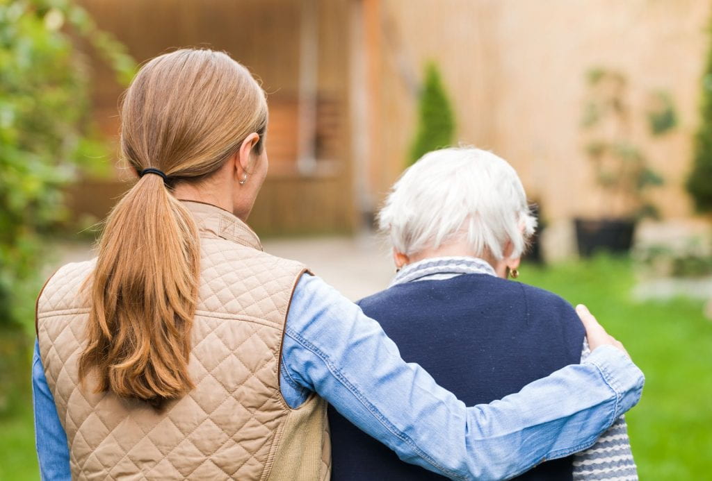 woman helping a senior walk