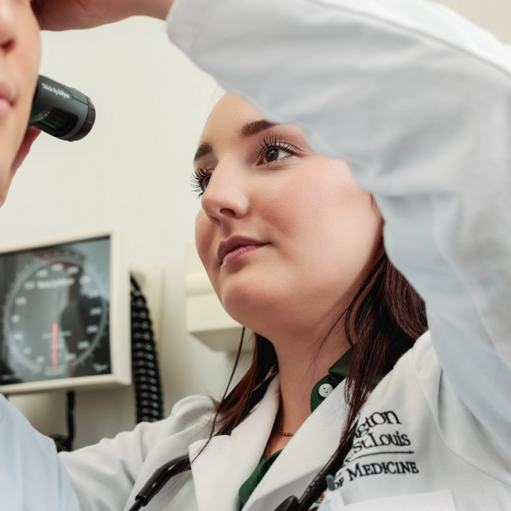 Jenna Bennett inspecting a patient's ear