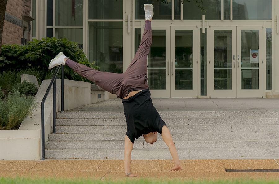 Aaron doing a cartwheel in front of Olin Business School in June 2022