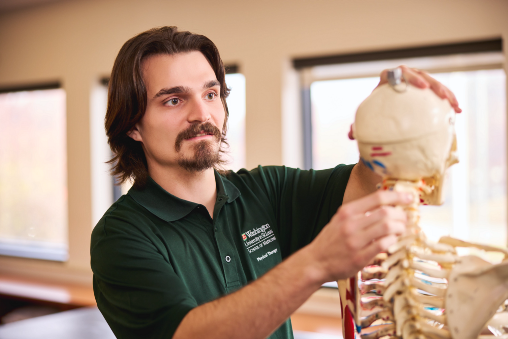 Leo Jacobs handling a demo skeleton in a physical therapy class